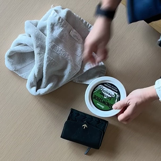 A time lapse video shows the application of Snowshoe Brand Leather Conditioner to a wallet. 