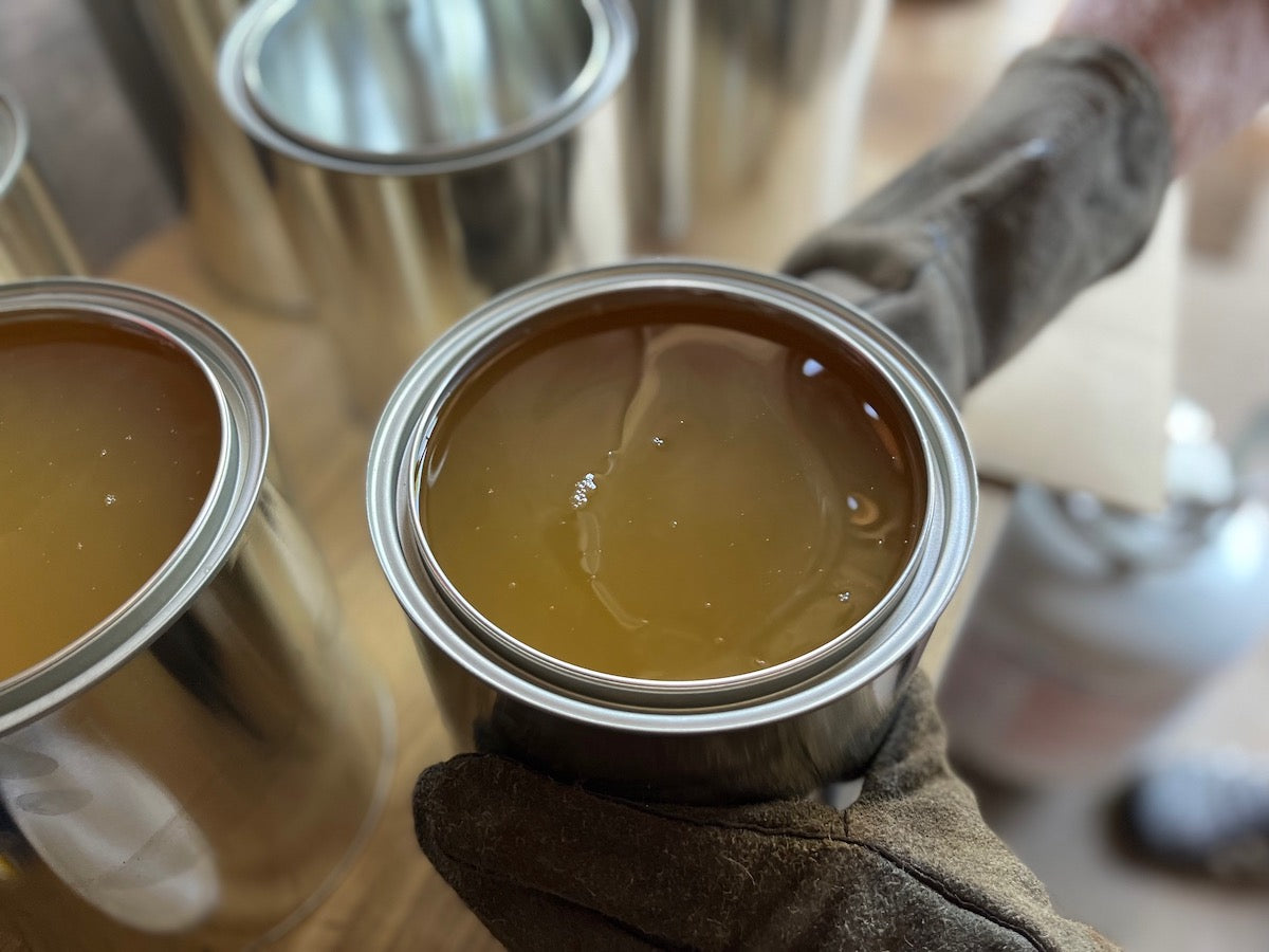 A gallon of Snowshoe Brand Leather Conditioner is displayed with its lid off. 